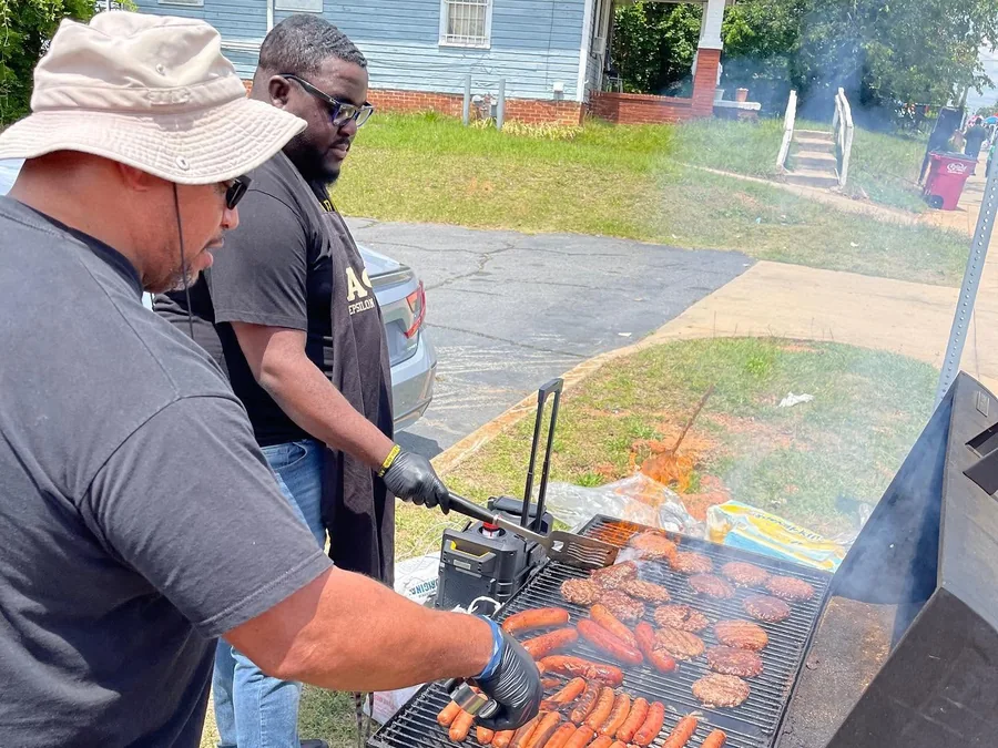 Two brothers of the chapter at a grill at a chapter cookout.
