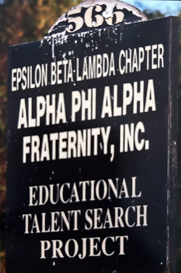 The chapter's sign board outside the house, reading Epsilon Beta Lambda Chapter, Alpha Phi Alpha Fraternity, Inc., Educational Talent Search Project.