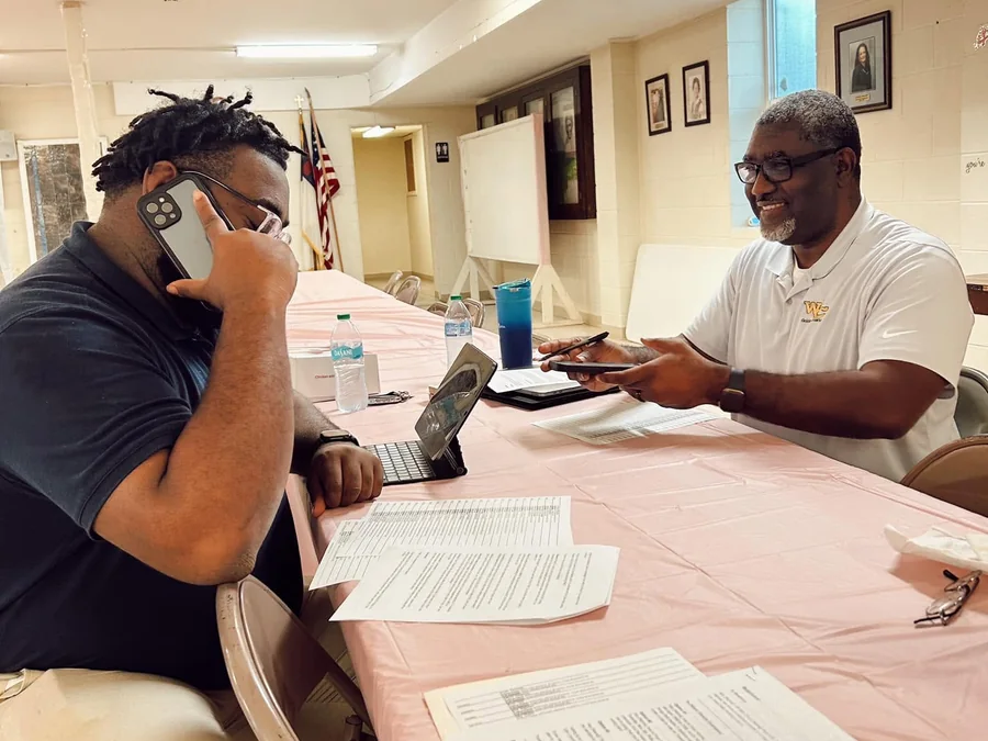 Brothers of the chapter phone banking at a table of call sheets.