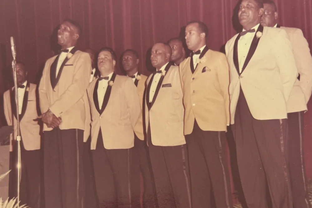A group of brothers in light blazers and dark ties, standing together.