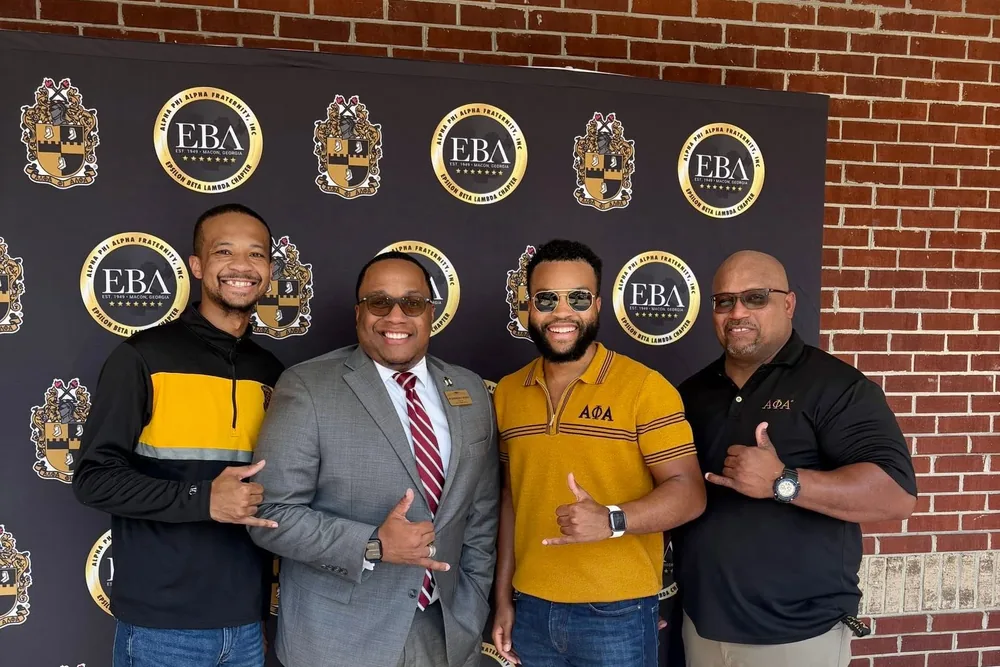 Brothers of the chapter in front of the chapter's step-and-repeat banner.